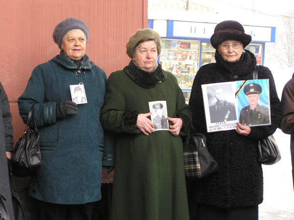 mothers holding photos of their perished sons