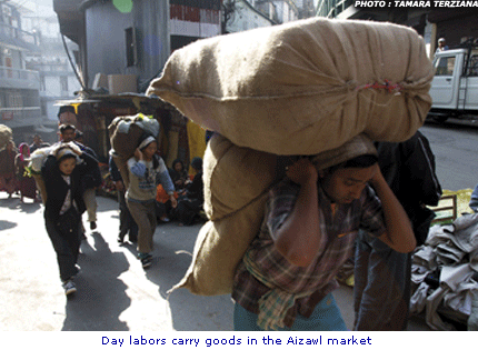 Refugee day labourers carry goods in the Aizawl market in Mizoram.jpg