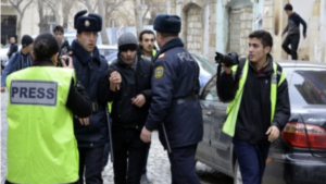 Mehman Huseynov (left in yellow vest) carrying out his duties as a photojournalist in 2012. Photo: IRFS.